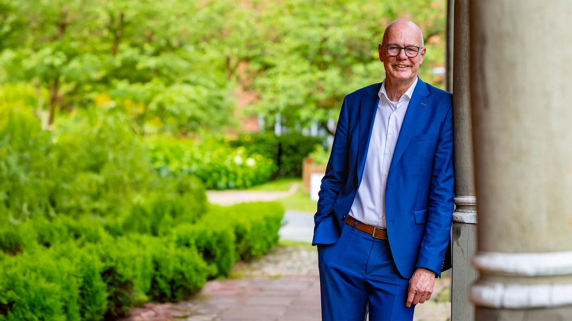 Wolfgang Klußmann, Bürgermeister der Gemeinde Wietze, vor einer Säulenhalle im Grünen